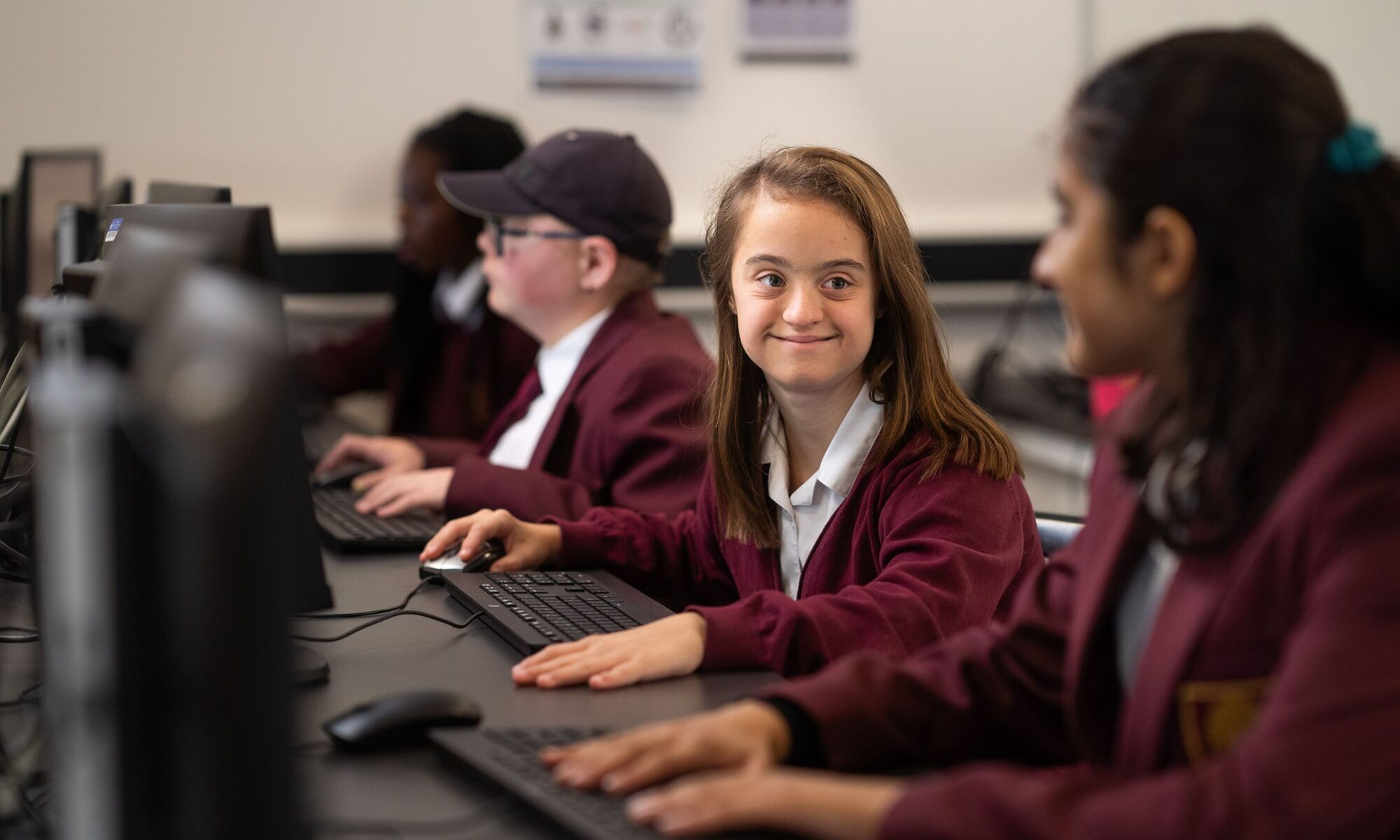 Row of four students in it suite working on pcs